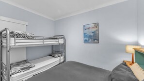 A bunk bed room with a framed picture on the wall.