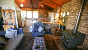 L’intérieur d’un chalet confortable, avec un salon, une cuisine et une cheminée.