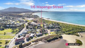 An aerial view of a coastal residential area with houses, roads, and a beach. - Marina Townhouse 1 - Unit 1 Wapengo St 6 (BERMAGUI)