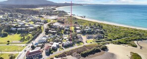 Een luchtbeeld van een kustgebied met woonhuizen, wegen en een strand.