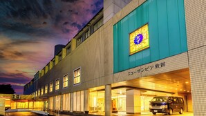 A modern building with a large illuminated sign, a covered entrance, and a parked van. - Hotel New Sunpia Tsuruga (Tsuruga)
