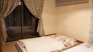 Un dormitorio con una cama, una ventana con cortinas y vistas al exterior.