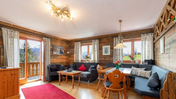 A wooden interior with a sofa, dining table, and chairs. - Ferienwohnung (10) im Birkenhof (Reit im Winkl)
