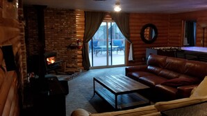 A cozy living room with a fireplace, leather sofa, and a coffee table.