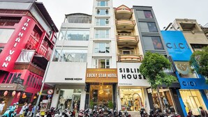 A hotel with balconies, a sign for Lucky Star Hotel, and a storefront for Siblin House.