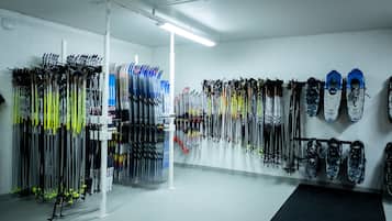 Un magasin d’articles de ski où l’on peut admirer de nombreux paires de skis et de snowboards exposés en rangées.