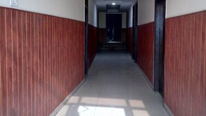 Un long couloir étroit, doté d’un sol carrelé et de lambris en bois sur les murs.