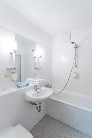 Ein modernes Badezimmer mit Waschbecken, Spiegel und Badewanne.