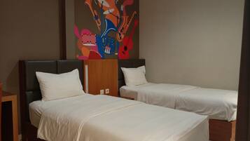 A hotel room with two single beds, a wooden headboard, and a colorful abstract painting on the wall.