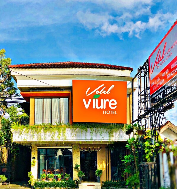 A hotel with a prominent orange sign reading "Vivre Hotel". - Votel Viure Hotel (Depok)