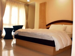 Ein ordentlich bezogenes Bett mit weißer Bettwäsche in einem Hotelzimmer.