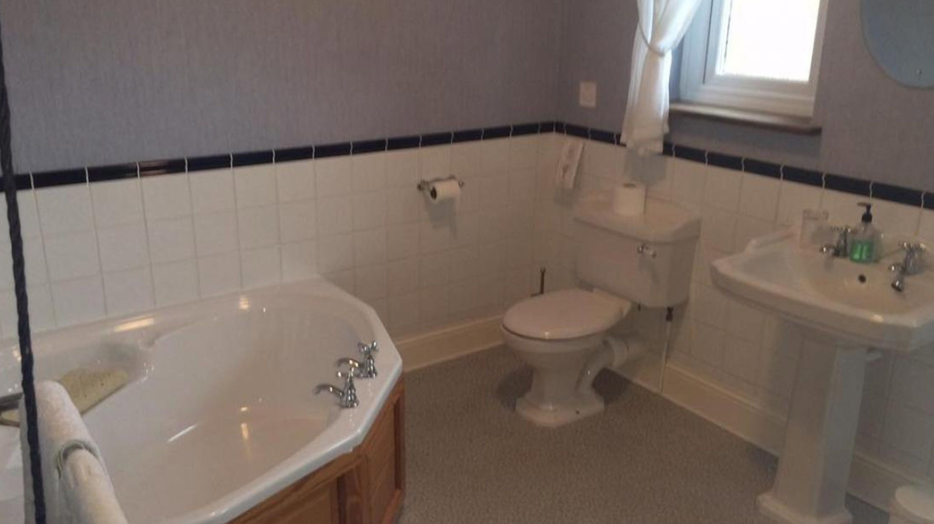 Un bagno con vasca, toilette e lavandino.