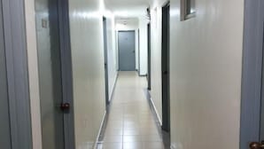 A long, narrow hallway with doors on both sides, leading to a door at the end. - Fully Hotel Desa Tebrau (Johor Bahru)