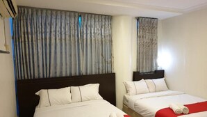 Two twin beds with white bedding and red accents, a dark headboard, and a window with curtains. - Fully Hotel Desa Tebrau (Johor Bahru)