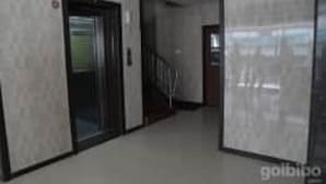A corridor with a door on the left, a staircase in the center, and a door on the right. - Krishna International (Chennai)