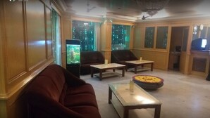 Amplia sala de estar con un sofá, dos sillones, una mesa de centro y un cuenco decorativo.