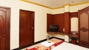 Una habitación de hotel con puertas de madera, un televisor, un escritorio y un armario.