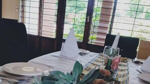 Una mesa de comedor con un centro de suculentas y patatas, un servilleta blanca y un vaso de agua.