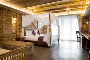 Un espacioso dormitorio con cama con dosel, paredes de madera y un gran ventanal.