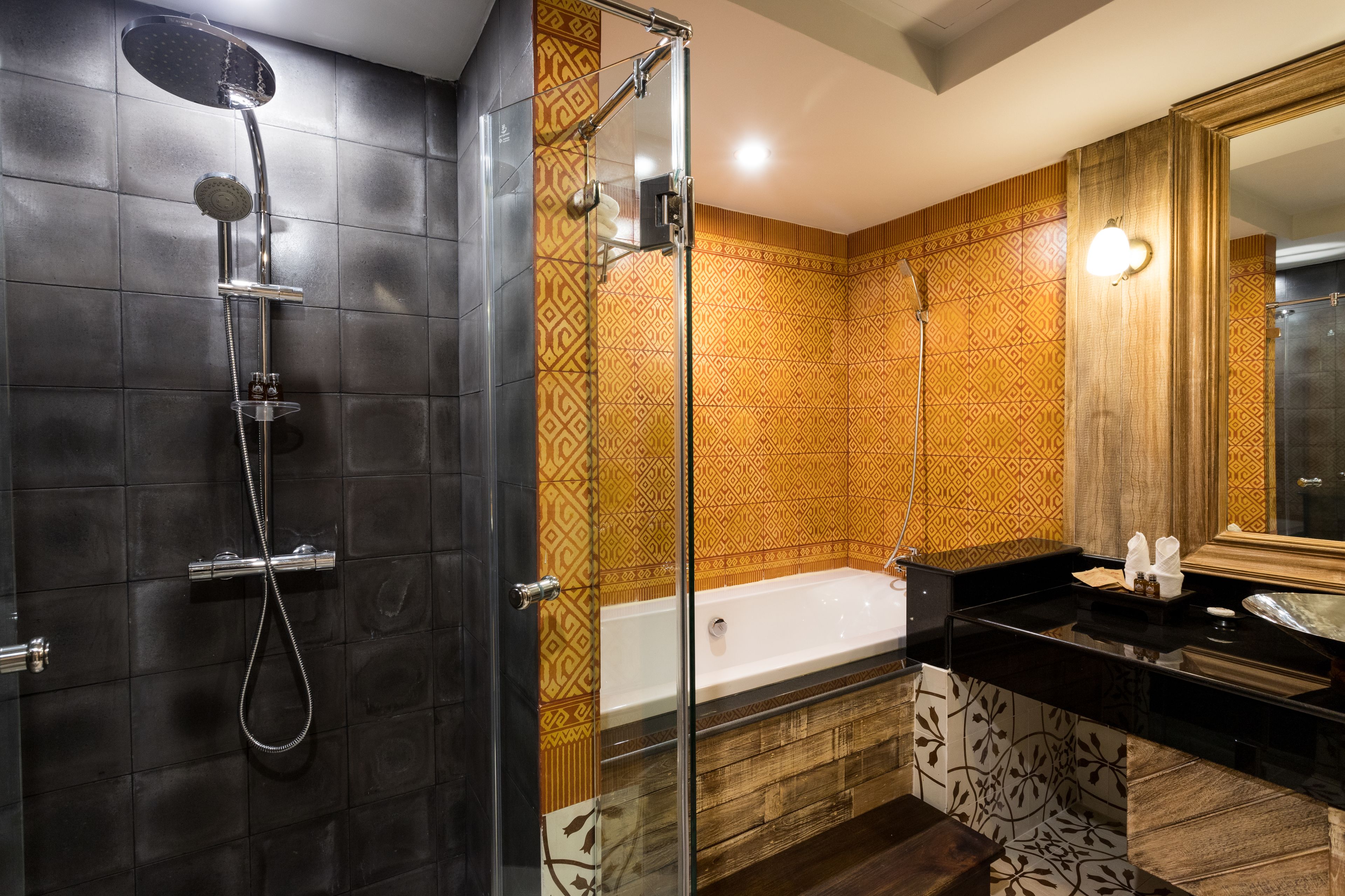 A modern bathroom with a glass-enclosed shower, a freestanding bathtub, and a vanity with a mirror.