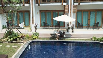 Alberca al aire libre y camastros