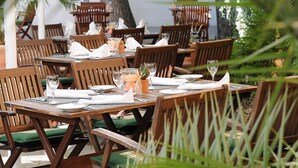 An outdoor dining area with wooden tables and chairs, arranged in a spacious layout. - Hotel Landgasthof Evering (Emsbueren)