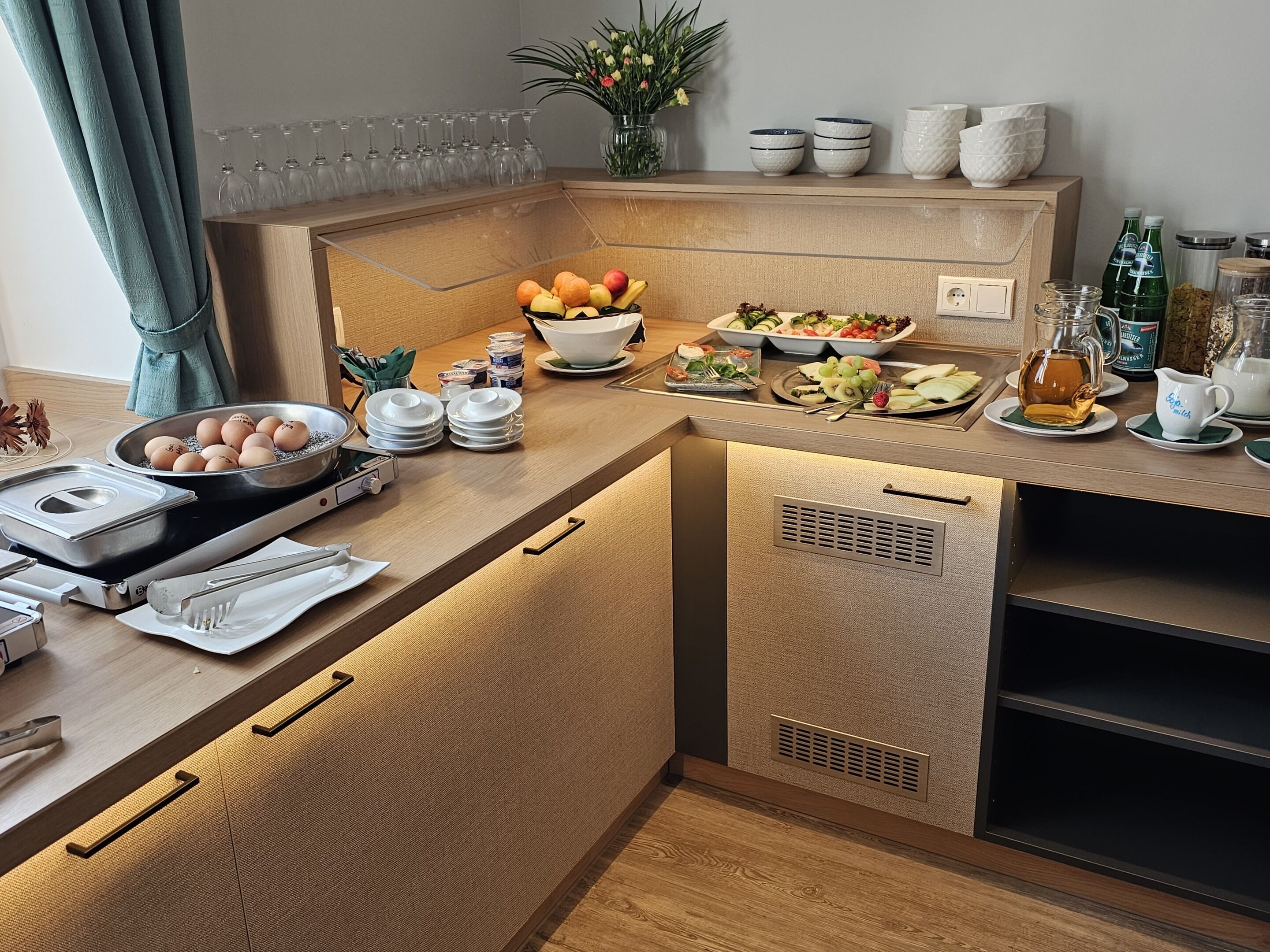 A modern kitchen with a wooden countertop, a built-in oven, and various kitchen utensils.