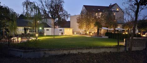 A residential area with houses, a well-maintained lawn, and outdoor lighting.