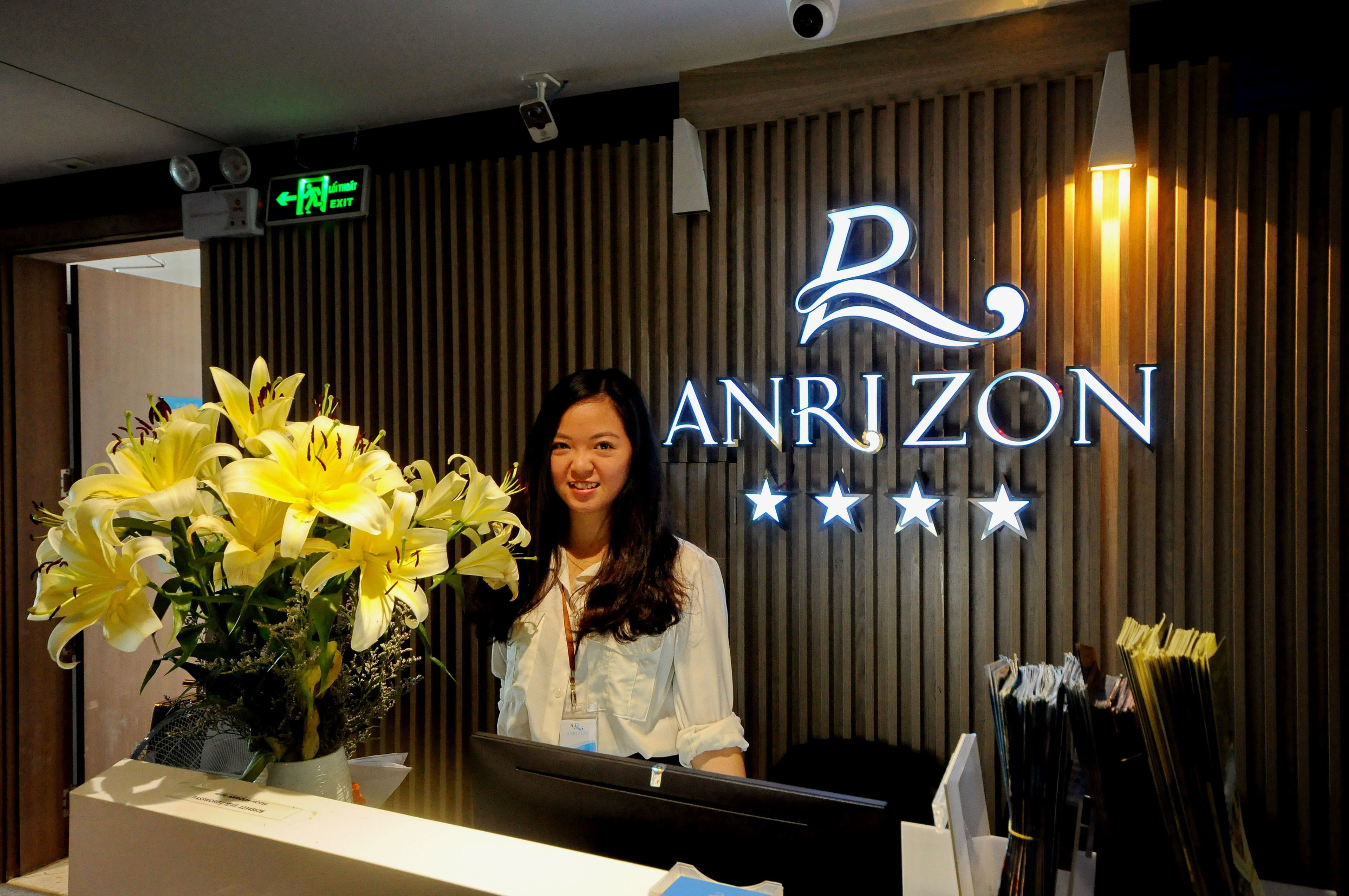 A reception desk with a sign reading "ANRIZON" and a floral arrangement.