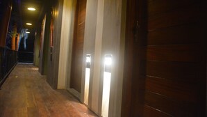 A corridor with wooden paneling and illuminated panels on the walls. - Royal Tusker Udawalawa (Udawalawa)
