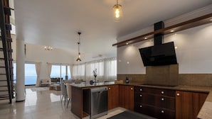 Una cocina moderna con lavavajillas, armarios de madera, horno empotrado y una isla grande con asientos.