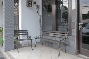 L’entrée d’un immeuble avec deux bancs à l’extérieur.