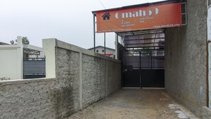A gated entrance to a building with a sign advertising Omah59 services. - RedDoorz @ Jagakarsa 2 (Jakarta)