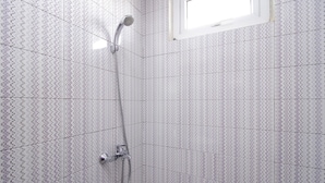 Eine Dusche mit Handbrause und verstellbarer Armatur.