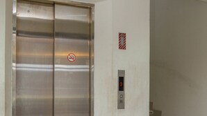 An elevator with a digital display and a no-smoking sign. - RedDoorz @ Malabar Street (Bandung)