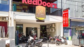 A RedDoorz store with a sign for D'Lima Kost Exclusive.