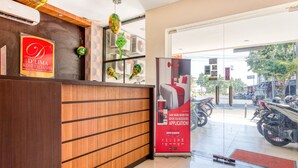 A reception desk with a wooden finish and a red sign advertising D'Lima Kost Exclusive.