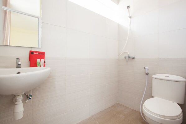 A bathroom with a white sink, toilet, and shower. - RedDoorz near Museum Angkut Batu 2 (Batu)