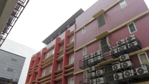 Un immeuble à plusieurs étages doté de balcons et de climatiseurs.