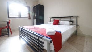 A bedroom with a bed, a desk, and a chair. - RedDoorz near Kartini Mall 2 Lampung (Bandar Lampung)