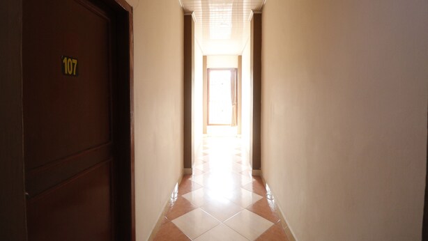A hallway with a door labeled 107, leading to a bright room. - RedDoorz near Kartini Mall 2 Lampung (Bandar Lampung)