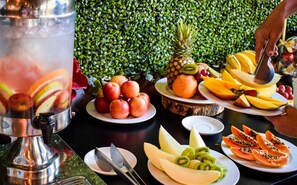 Une table avec différents fruits et un distributeur de boissons.