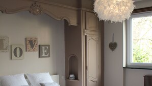 Un dormitorio con una cama grande, una lámpara colgante y una ventana con vistas.