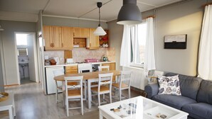 A compact living space with a kitchen, dining area, and a seating area with a sofa and coffee table.