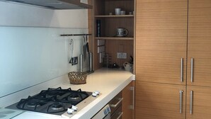 Eine moderne Küche mit Edelstahlgeräten, Holzschränken und einem eingebauten Backofen.