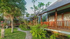 Un bâtiment de style traditionnel, avec un chemin de pierre menant à une terrasse en bois.