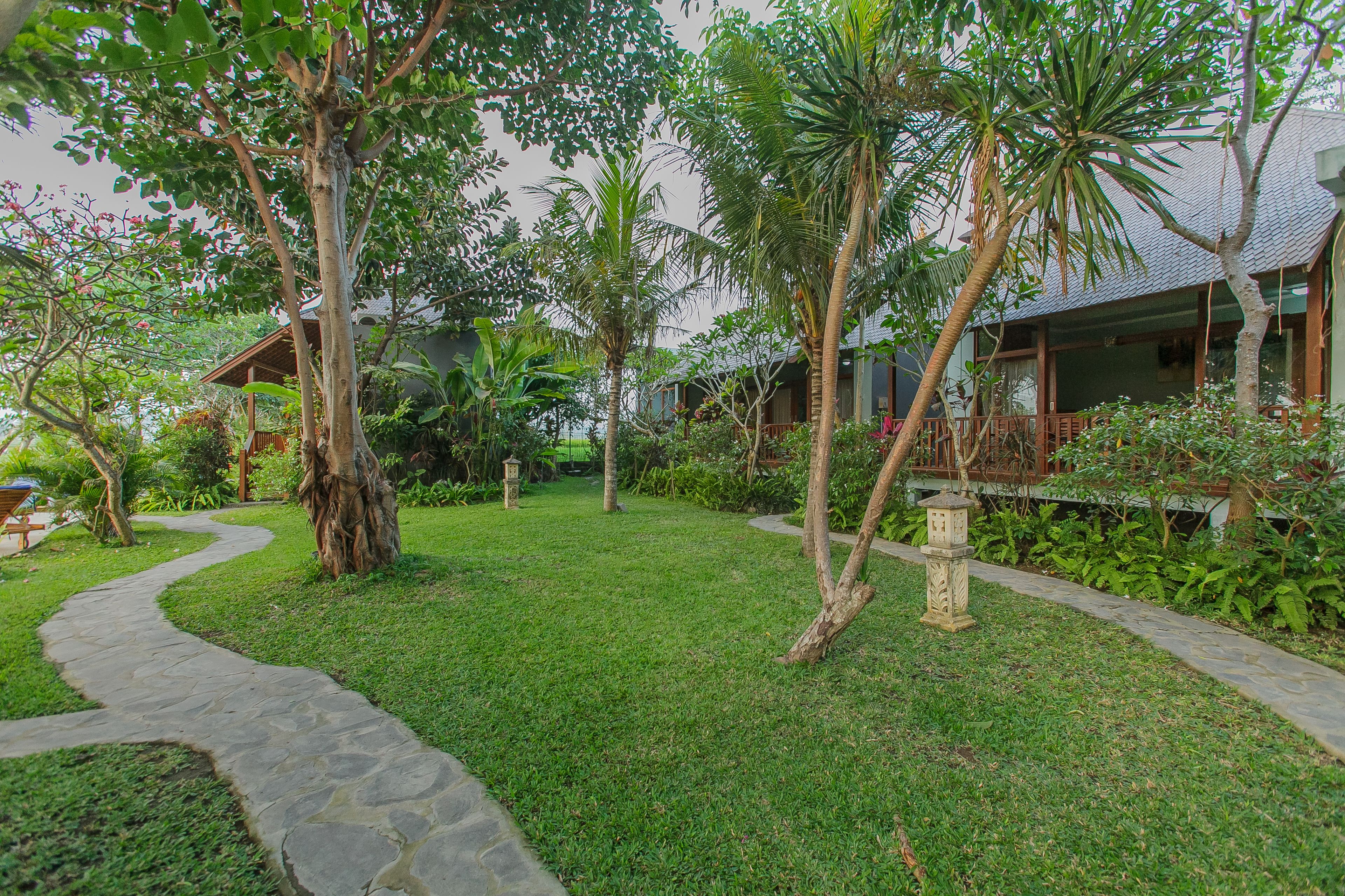 A well-maintained garden with a stone pathway leading to a wooden structure.