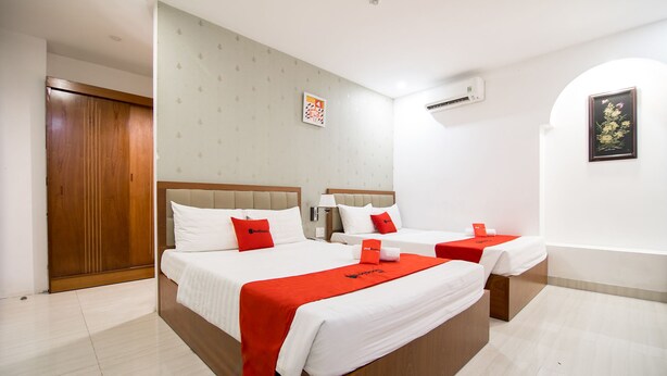 Habitación de hotel con dos camas, un armario y un baño.