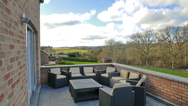A patio with outdoor furniture and a view of the countryside.