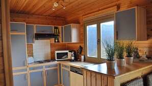 Eine kleine Küche mit Holzausstattung, einer Mikrowelle und einem Spülbecken.